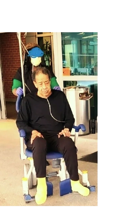 Person seated in indoor institutional rehabilitation setting